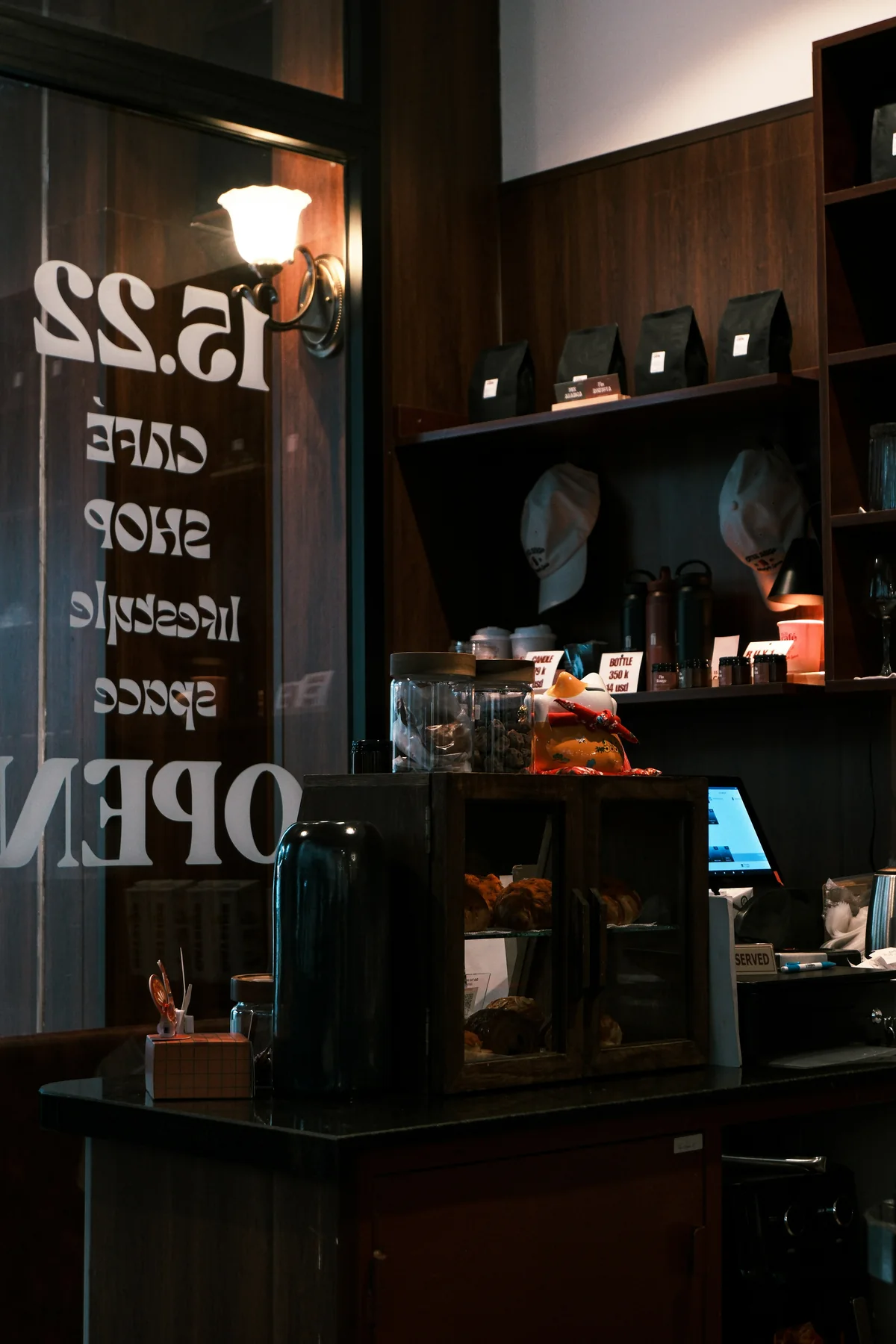 Cozy dark café counter with pastries and coffee bags