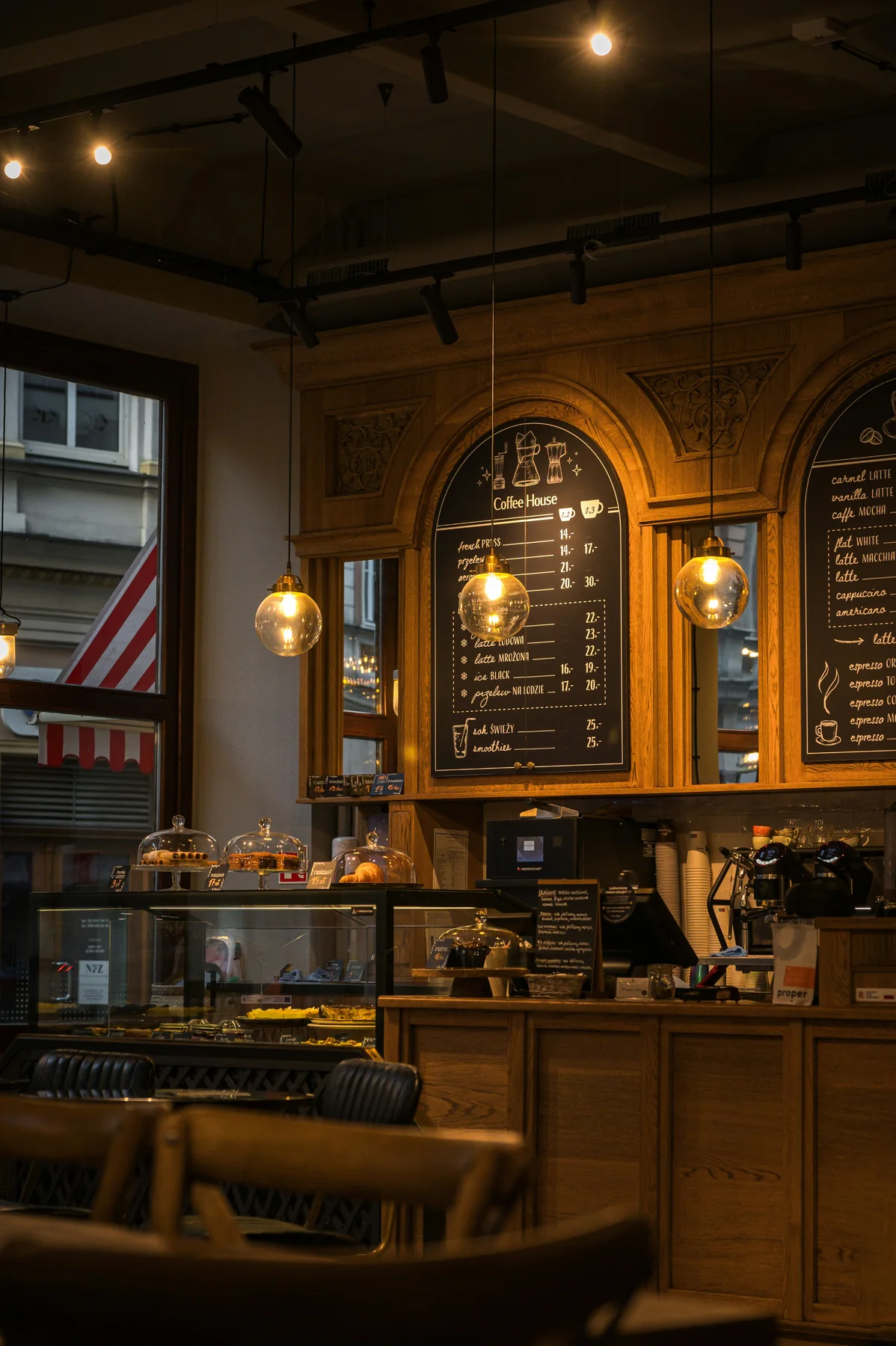 Warm café interior with pastry counter and menu boards